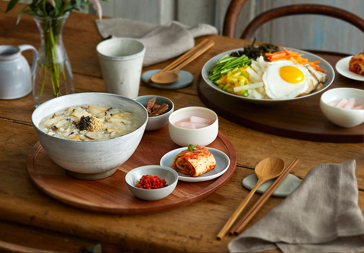 비빔밥과 전복죽이 식탁 위에 놓여있는 모습입니다.